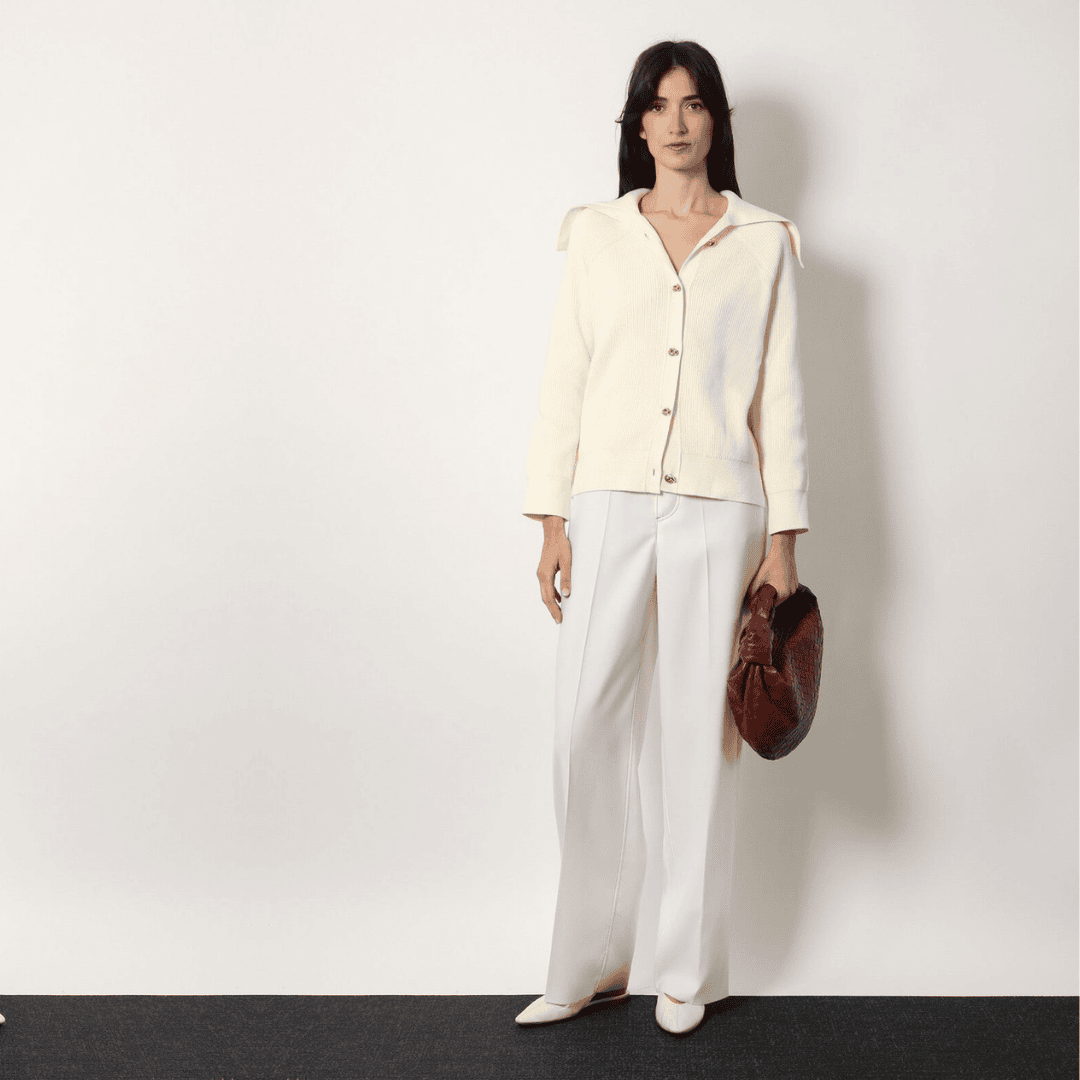2025 fashion look – ivory cardigan, tailored trousers, and brown woven clutch from spring to winter collections.
