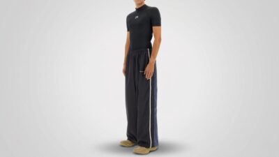 Black tight-fit compression t-shirt, paired with navy blue loose-fit track pants with side stripes and tan athletic sneakers for THE WISHLINE luxury men's activewear and designer sportswear collection navigation.
