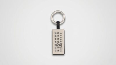 MM6 Maison Margiela silver-tone rectangular metal keychain featuring the signature engraved numeric logo grid with a circled number 6 for THE WISHLINE luxury men's assorted accessories and keyrings collection navigation.