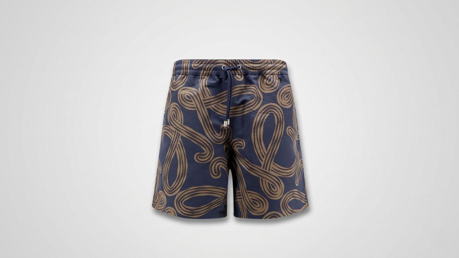 Navy blue swim shorts featuring an allover tan abstract swirling rope pattern, an elastic drawstring waistband, and metal aglets for THE WISHLINE luxury men's beachwear and swimwear collection navigation.