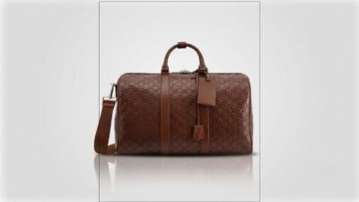 Gucci brown GG monogram debossed leather duffel travel bag featuring twin top handles with a signature green and red Web loop for THE WISHLINE luxury men's duffel and travel bags collection navigation.