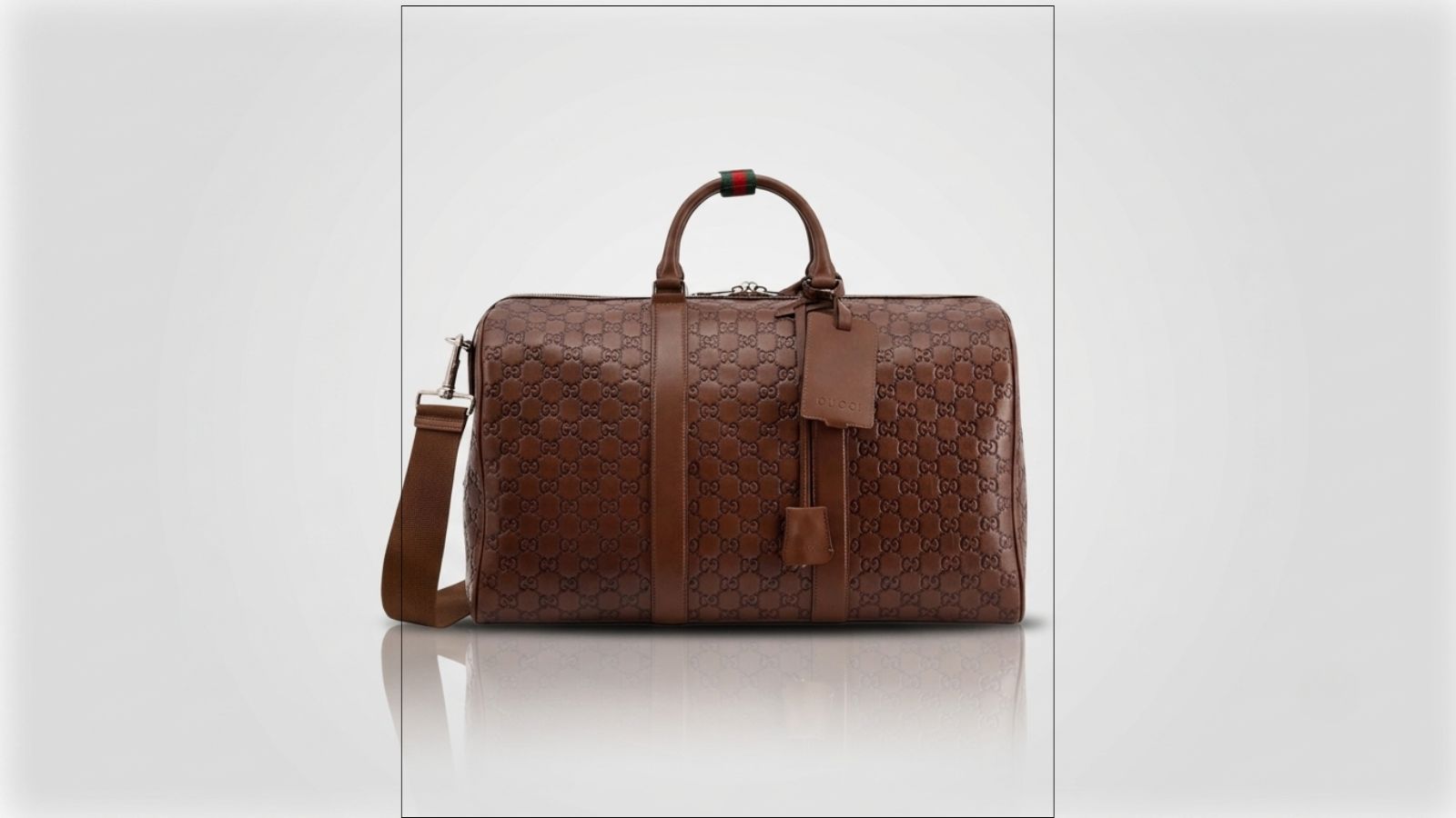 Gucci brown GG monogram debossed leather duffel travel bag featuring twin top handles with a signature green and red Web loop for THE WISHLINE luxury men's duffel and travel bags collection navigation.