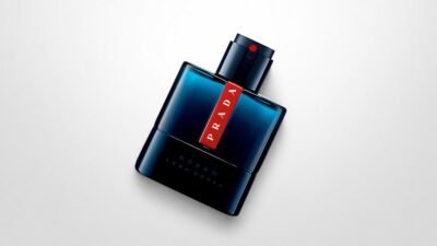 Prada Luna Rossa Ocean Eau de Toilette bottle featuring a deep blue translucent glass design with the iconic red stripe logo insert for THE WISHLINE luxury men's eau de toilette and cologne collection navigation.