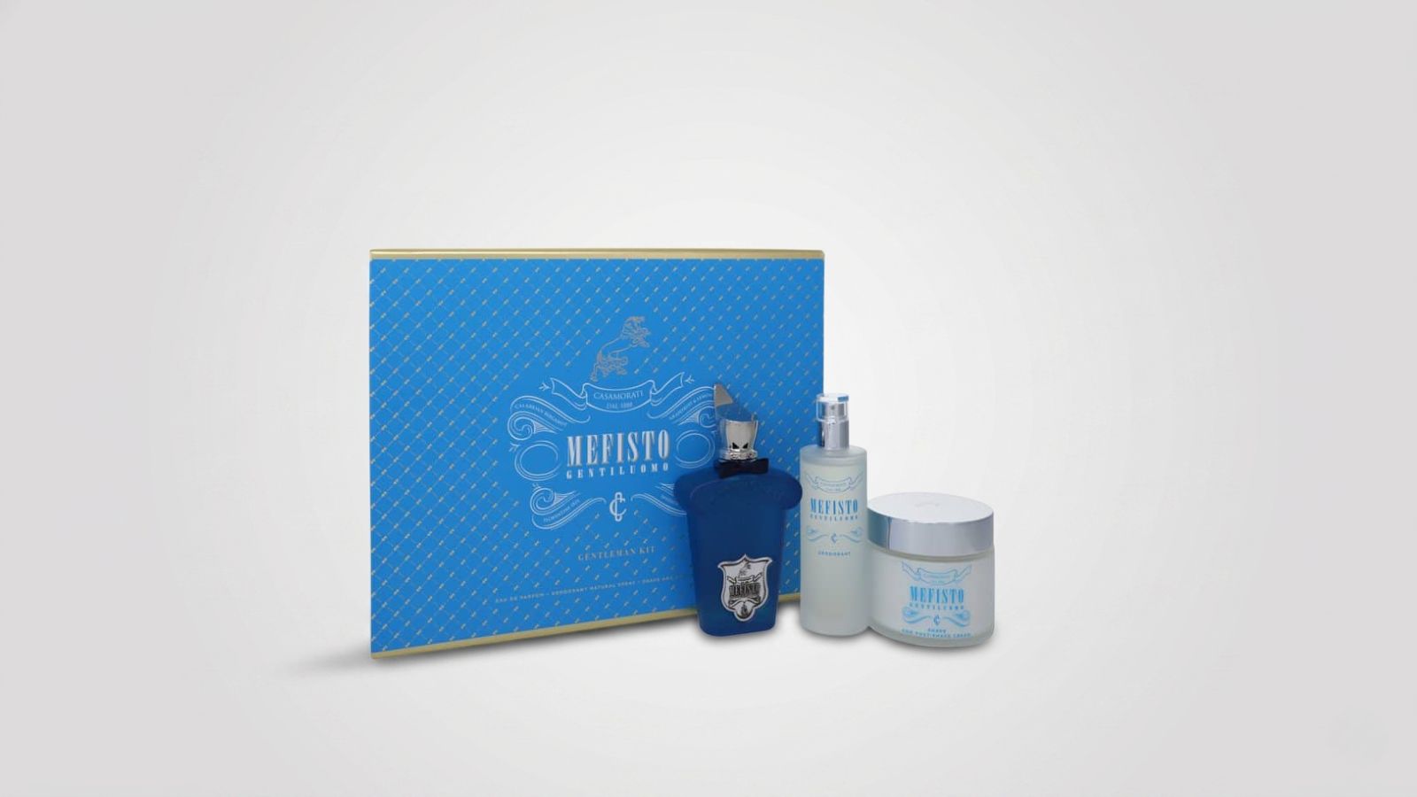 Men's luxury grooming gift set featuring an eau de parfum bottle, a body spray, and an aftershave cream jar arranged with a matching blue and gold presentation box for THE WISHLINE luxury men's parfum gift sets and fragrance collection navigation.