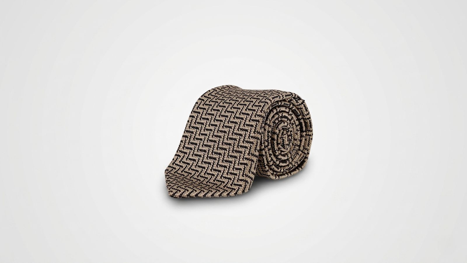Tom Ford beige and black silk jacquard necktie featuring an intricate woven geometric chevron pattern for THE WISHLINE luxury men's ties and formal accessories collection navigation.