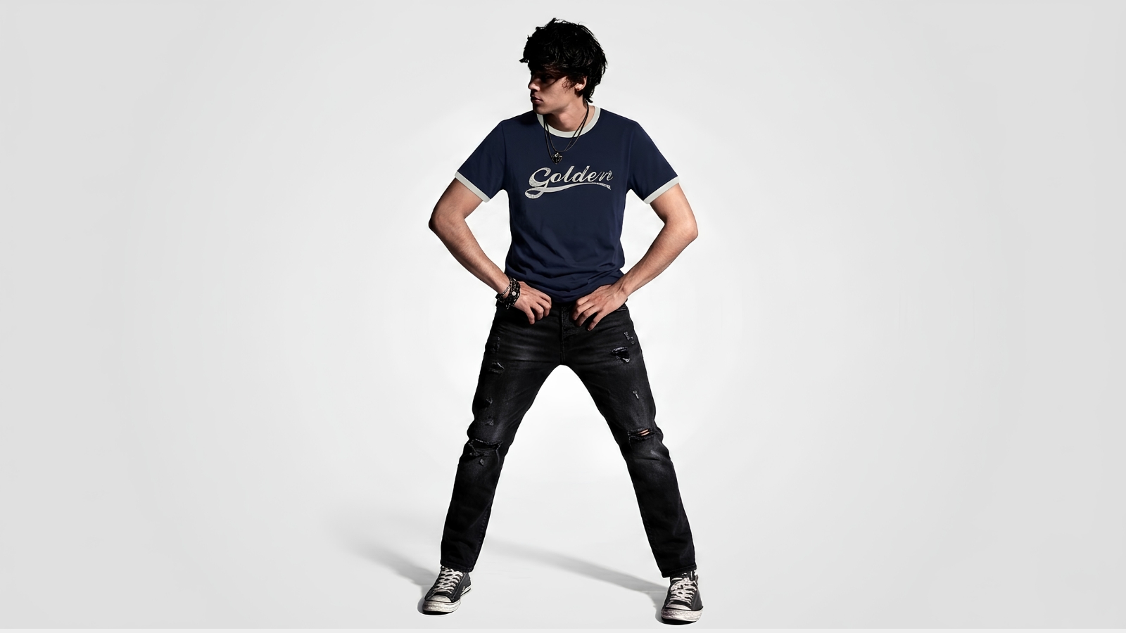 Navy blue distressed ringer T-shirt featuring a white cursive logo graphic paired with black ripped jeans for THE WISHLINE luxury men's T-shirts and streetwear collection navigation.