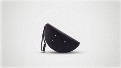 Maison Margiela black leather Half-Moon pouch featuring a zip-top closure and signature white four-stitch moniker for THE WISHLINE luxury men's wallets and accessories collection navigation.