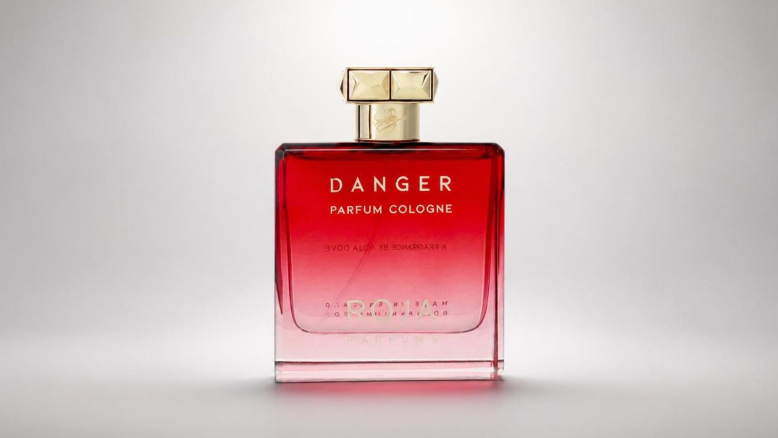 Roja Parfums Danger Parfum Cologne bottle featuring its signature vibrant red gradient glass design and a faceted gold-tone cap for THE WISHLINE luxury unisex parfum and niche fragrance collection navigation.