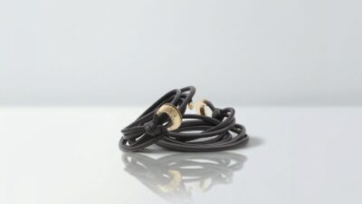 Luxury multi-wrap black leather cord belt featuring polished gold crescent buckle hardware for THE WISHLINE designer women's belts collection navigation.