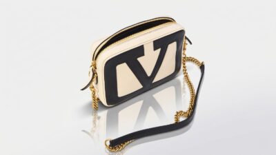 Valentino Garavani cream and black leather Locò camera bag featuring a prominent cut-out VLogo design and a gold-tone chain shoulder strap for THE WISHLINE luxury crossbody and shoulder bags navigation.