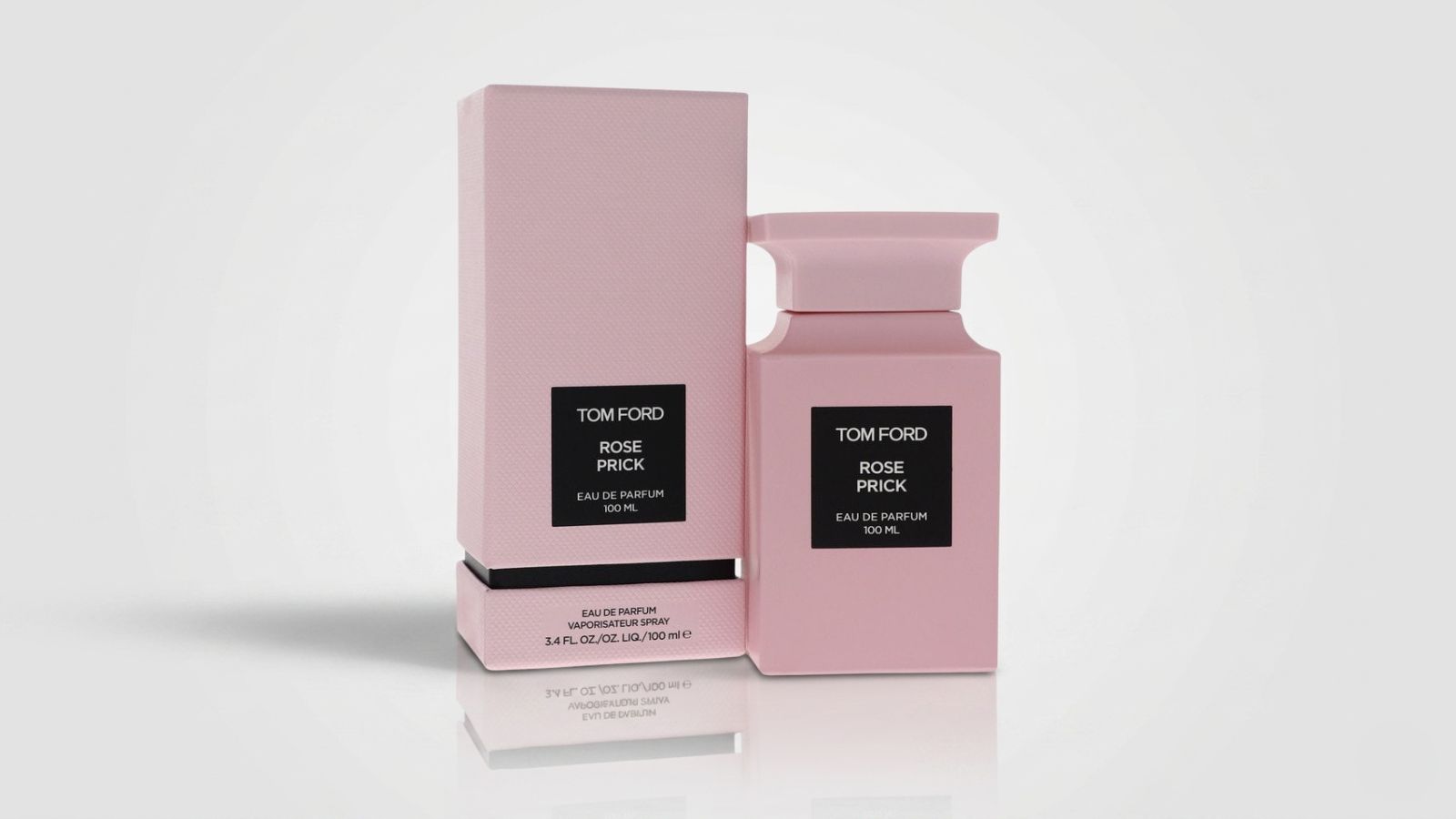 Luxury women's matte pink architectural perfume bottle standing next to its matching textured pink packaging box for THE WISHLINE luxury women's eau de parfum and designer fragrance collection navigation.