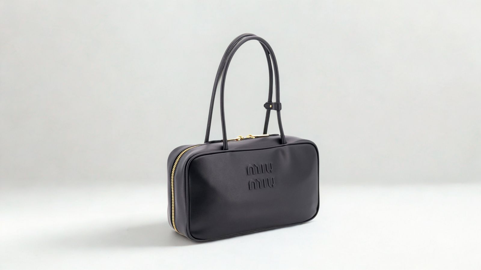 Miu Miu Arcadie black leather top-handle handbag on a neutral background for THE WISHLINE designer handbags collection navigation.