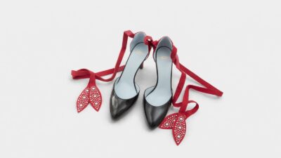 Valentino Garavani black patent leather pointed-toe pump heels with studded red ankle tie ribbons for THE WISHLINE luxury women's shoes navigation.
