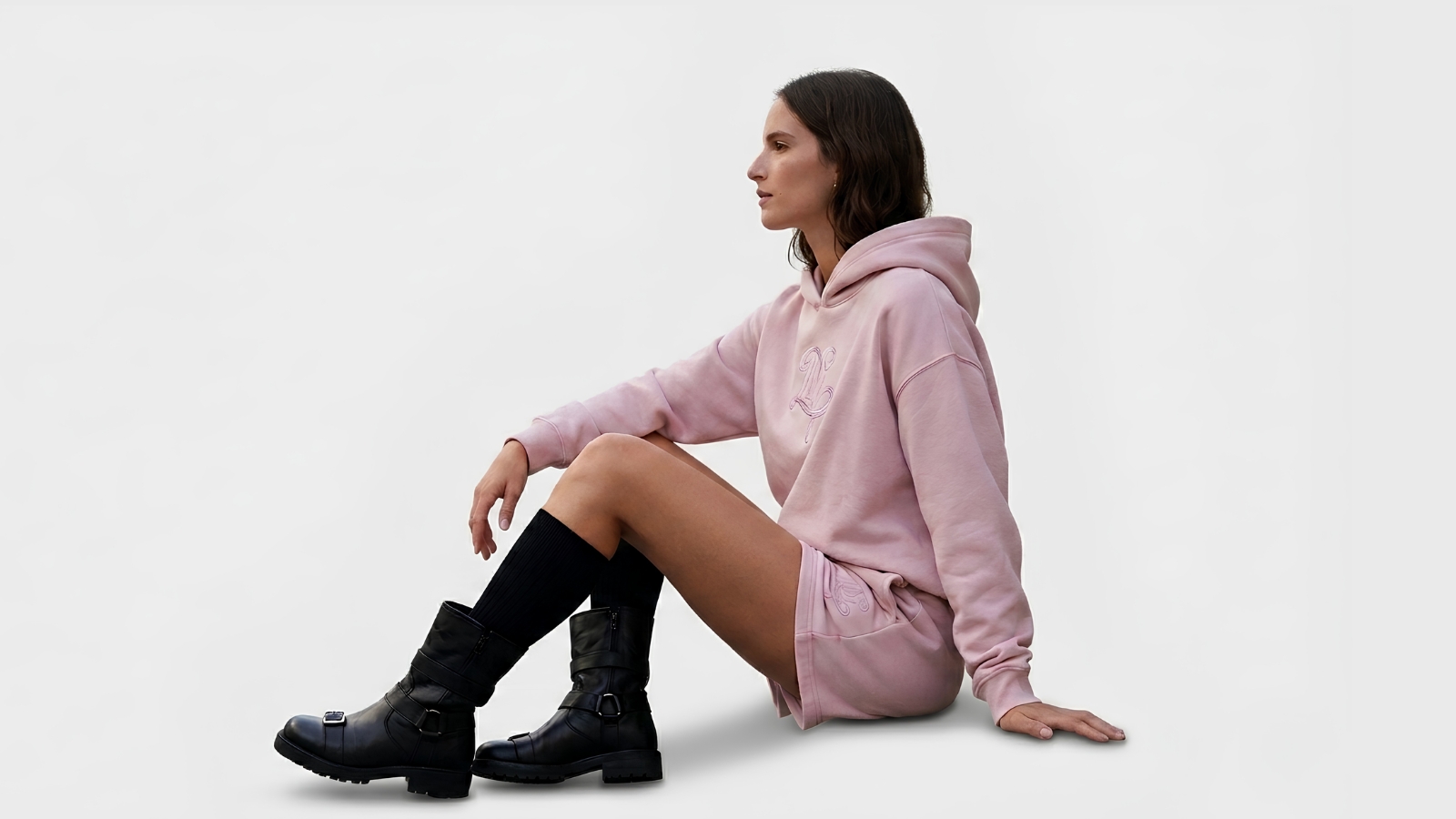 Model styling casual high-waisted black tailored shorts for THE WISHLINE luxury women's shorts collection navigation.