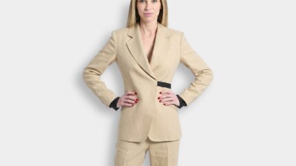 Model wearing a tailored tan linen blazer jacket with a black buckle waist detail for THE WISHLINE designer suits and blazers navigation.