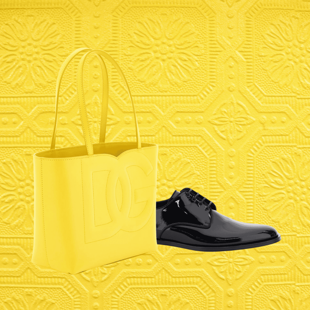 Yellow Dolce & Gabbana tote bag and black shoes with a yellow patterned background.