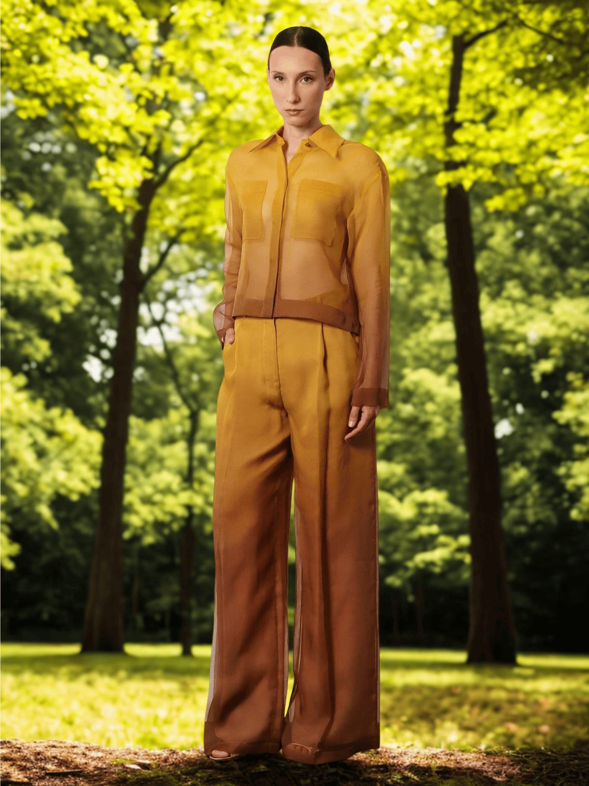 Woman wearing a golden-brown sheer blouse and wide-leg trousers from the Max Mara FW25 collection — featured in THE WISHLINE’s designer edit.