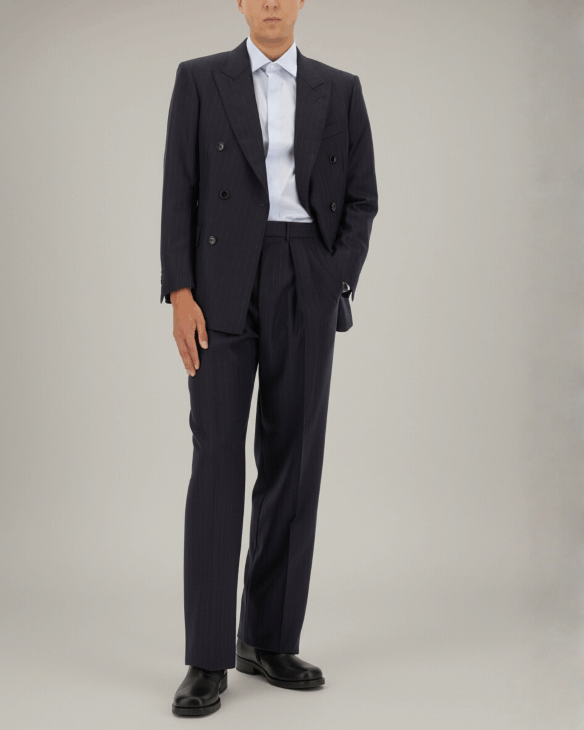 Man wearing a tailored navy pinstripe blazer and trousers with a white shirt, featured in THE WISHLINE Men’s Seasonal Offers collection.