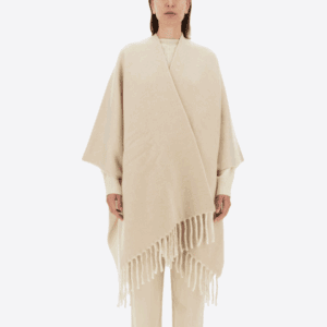 Woman model wearing a cream colour wool and cashmere stole/poncho.