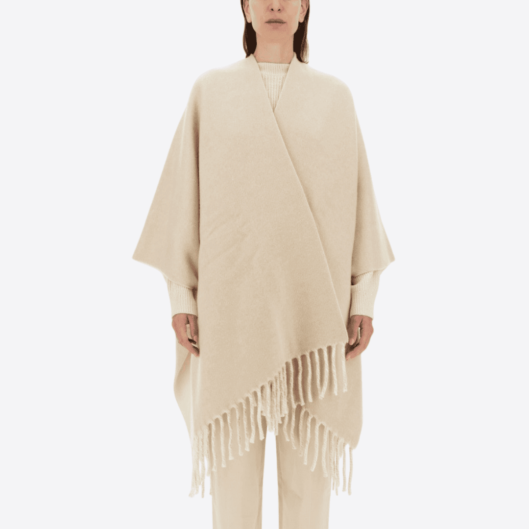 Woman model wearing a cream colour wool and cashmere stole/poncho.