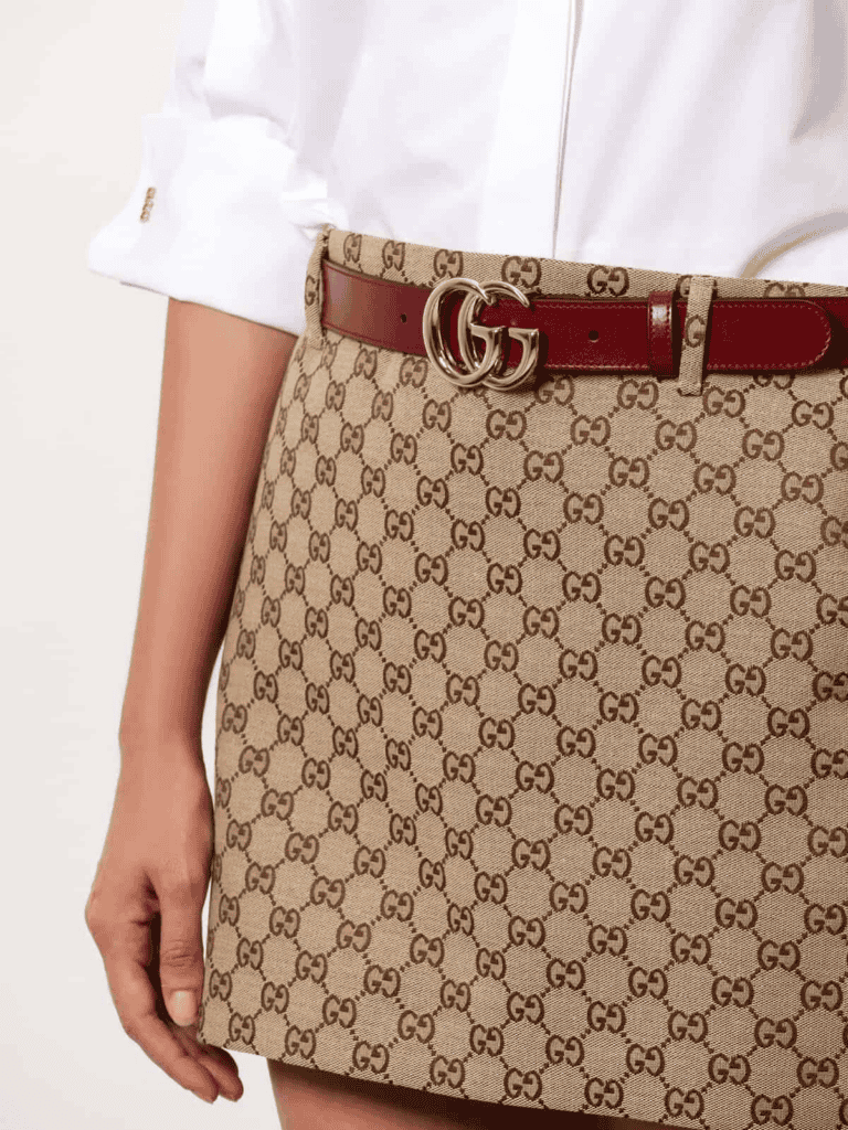 Woman model wearing Gucci skirt and Gucci GG Marmont belt showcasing THE WISHLINE Belts Collection.